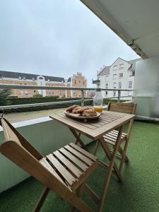 a wooden table with a plate of food on a balcony at T2 Evry Centre - Proche de Orly et Paris in Courcouronnes