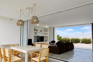 a dining room and living room with a table and chairs at Villa Codolar in Cala Morell