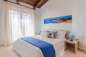 a bedroom with a large bed with blue lamps on a table at Gravina Residence - Villas & Apartments in Costa Paradiso