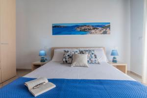 a bedroom with a large bed with a blue blanket at Gravina Residence - Villas & Apartments in Costa Paradiso
