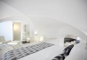 a white bedroom with a bed and a chair at Cloud 9 in Imerovigli +32 photos