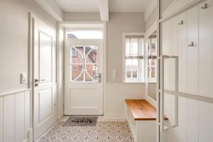 a hallway with a white door and a wooden bench at Wiesen Engel in Oldsum
