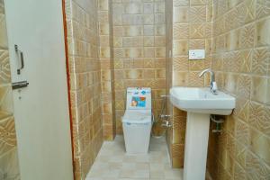 a small bathroom with a sink and a trash can at Narayan Homestay & Guest House in Haridwār