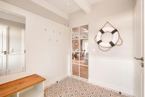 a bathroom with white walls and a mirror and a table at Wiesen Engel in Oldsum