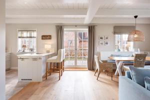 a kitchen and living room with a table and a dining room at Wiesen Engel in Oldsum