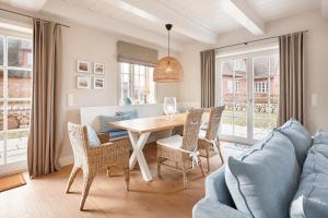 a living room with a table and a blue couch at Wiesen Engel in Oldsum +21 photos