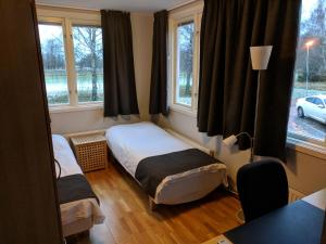 a small bedroom with two beds and windows at Hotell Hässlö in Västerås +16 photos