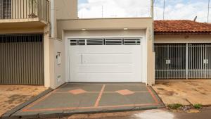 a white garage door on a house at Jahu Center Casas Un 6 in Jaú