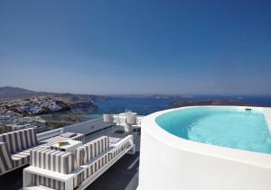 a swimming pool on the side of a building with chairs at Cloud 9 in Imerovigli