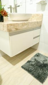 a bathroom with a sink and a bathroom rug at Jahu Center Casas Un 6 in Jaú +47 photos