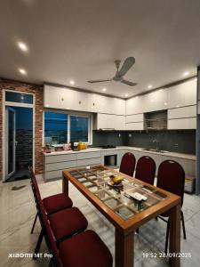 a kitchen with a wooden table and red chairs at Long Homestay Phuc An in Ðức Hòa