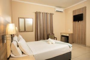 a hotel room with a bed and a mirror at Tudor House Hotel in Durban +18 photos