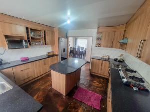 a kitchen with wooden cabinets and black counter tops at Agreste Homes in Kasama