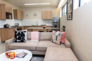 a living room with a couch and a kitchen at Amaryllis Residences Mount Pleasant in Blantyre