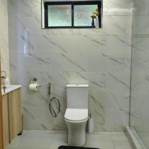 a white bathroom with a toilet and a window at Amaryllis Residences Mount Pleasant in Blantyre +26 photos