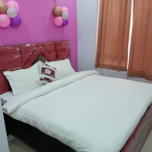a bedroom with a bed with purple walls and balloons at AG Hotel in Zirakpur