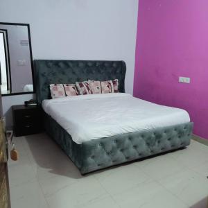 a bed in a room with a purple wall at AG Hotel in Zirakpur +3 photos