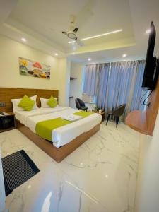 a bedroom with a large bed and a television at Hotel Mount View Inn with terrace Ganga view- near Laxman jhula, Tapovan Rishikesh in Rishīkesh