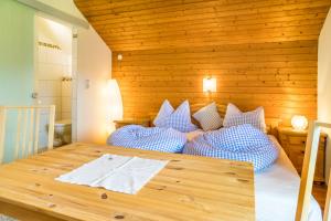 a bedroom with a bed with blue and white pillows at Bambichl Hoamat in Fuschl am See