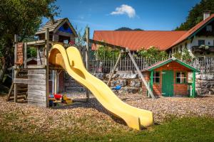 a playground with a slide and a play house at Bambichl Hoamat in Fuschl am See