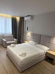 a bedroom with a large white bed and a couch at Blue Studios by Comfort Suites in Golem