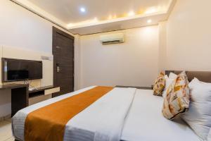 a hotel room with a bed and a television at FabHotel Prime The Bentree in Bhopal