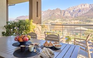 a table with a bowl of fruit and bread on a balcony at Bellagio Village - Holiday Apartments by the Lake - Seasonal Warm Pool and Sauna in Oliveto Lario