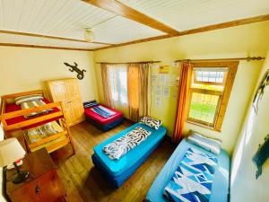 a room with a bed and two ottomans at Jikeleza Lodge in Port Elizabeth