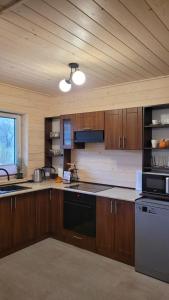 a kitchen with wooden cabinets and a stove top oven at Domek w Zabrzeży in Łącko