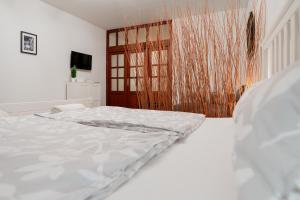 a white bed in a room with a window at Vincellér Apartman in Villány +15 photos