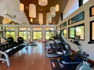 a gym with several treadmills and elliptical machines at J&Y Happy Home in Ban Rong
