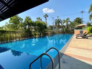 a large blue swimming pool with two chairs around it at J&Y Happy Home in Ban Rong