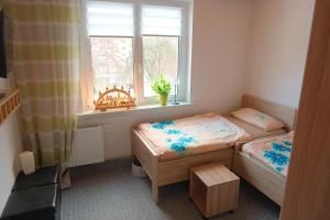 two beds in a small room with a window at Gabis Ferienwohnung Zwickau in Zwickau