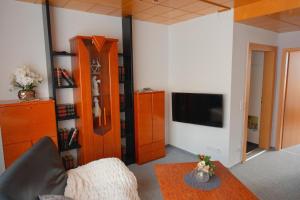 a living room with a couch and a table and a tv at Gabis Ferienwohnung Zwickau in Zwickau