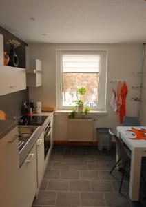 a kitchen with a sink and a window and a table at Gabis Ferienwohnung Zwickau in Zwickau
