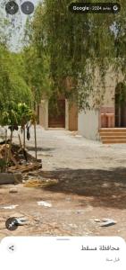 a picture of a building with trees and a street at Room Quriyat in Ramlah