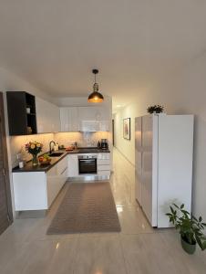 a kitchen with white cabinets and a refrigerator at Marina District in Pieta +4 photos