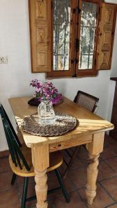 a wooden table with a vase of flowers on it at MOZa LUZe - Off Grid Casa Rural in El Pilar y Provincias