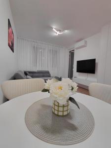 a vase of flowers on a table in a living room at High Above 6 in Vranješ