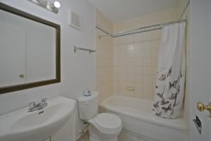 a bathroom with a toilet and a sink and a bath tub at MXP Special Rooms in Saskatoon