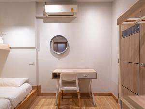 a small bedroom with a desk and a mirror at The Goose House Ubon in Ban Na Khwai