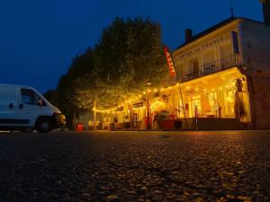 a white van parked in front of a building with lights at hotel de france in Vatan
