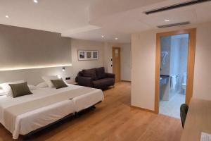 a bedroom with a bed and a couch and a chair at Hotel Tanit in Benidorm +30 photos