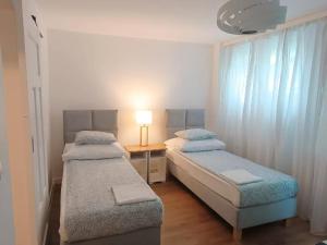 a bedroom with two beds and a table with a lamp at Close to everywhere, cosy place in Krakow