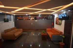 a living room with two couches and a tv at Hotel Stay Bliss Marathahalli in Bangalore