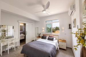 a bedroom with a bed and a sink and a mirror at Villa Mesogeios 39 in Paralimni +72 photos