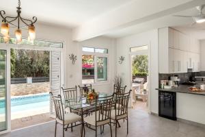 a kitchen and dining room with a glass table and chairs at Villa Mesogeios 39 in Paralimni