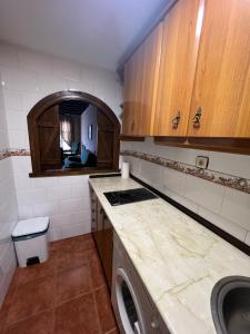 a kitchen with a sink and a counter with a washer at Apartamentos Turísticos La Posada in Oropesa +72 photos