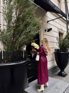 a little girl in a purple dress holding flowers at Wall Street - Maestro in Odesa