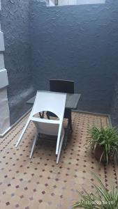 a white table and a chair on a patio at Riad Fadela in El Jadida